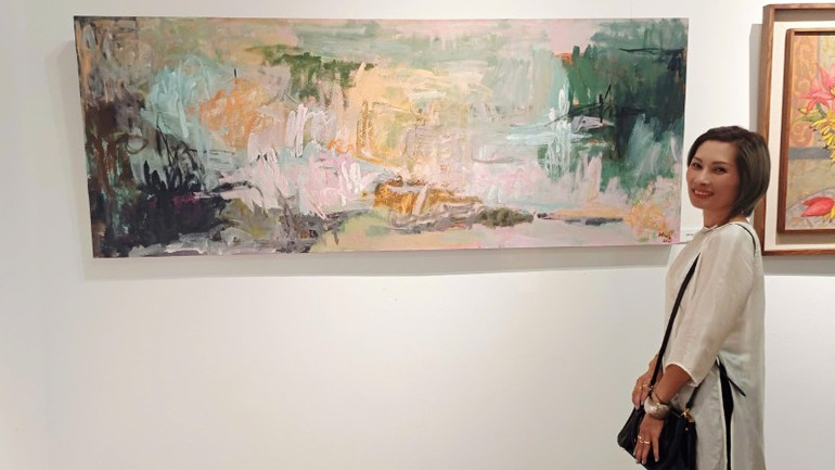 Artist Nguyen Hoang Lan with her work at the exhibition. z6873030080970-06fab762a4ede1b4fb655347ec29d9eb-3792.jpg