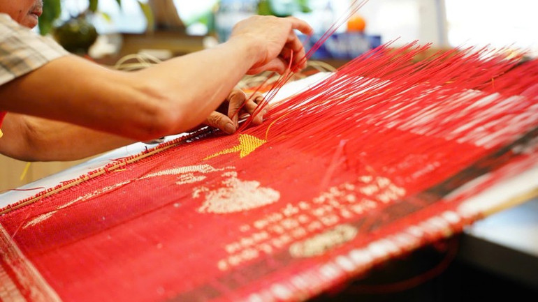Bàn tay tài hoa của Nghệ nhân nhân dân Nguyễn Văn Trung đang thực hiện một công đoạn tác phẩm chân dung Bác Hồ. img-20250812-121810-5775.jpg