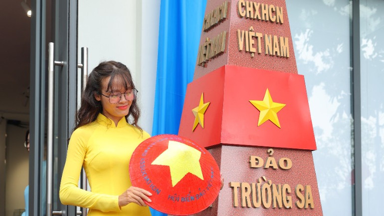 A tourist from Ninh Binh proudly takes a souvenir photo next to a model of the landmark. troc1955-1760.jpg
