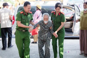 Cán bộ, chiến sĩ Công an xã Phú Ninh hỗ trợ người cao tuổi đi làm giấy tờ cá nhân.