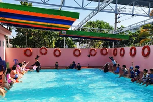 Các em học sinh thích thú tham gia lớp học bơi.
