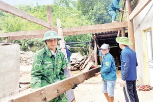 Cán bộ, chiến sĩ Đồn Biên phòng Nhôn Mai phối hợp các lực lượng di dời nhà dân bị ảnh hưởng do lũ quét.