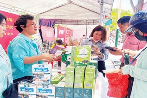 Người dân mua sắm tại các gian hàng trong hội chợ. (Ảnh XUÂN TRƯỜNG)