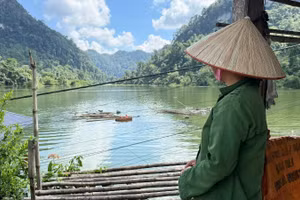 Người dân bất lực nhìn nhà ở chìm dưới nước ngập. (Ảnh: TUẤN SƠN).