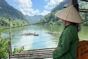 Người dân bất lực nhìn nhà ở chìm dưới nước ngập. (Ảnh: TUẤN SƠN).