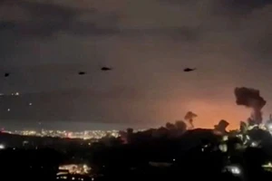 Trực thăng bay qua khu vực khói bốc lên từ loạt vụ nổ ở thủ đô Caracas, Venezuela, ngày 3/1/2026. (Ảnh: TTXVN)