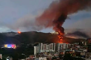 Khói lửa bốc lên tại khu phức hợp quân sự Fuerte Tiuna lớn nhất Venezuela, sau một loạt tiếng nổ ở Thủ đô Caracas, ngày 3/1/2026. (Ảnh: France24/TTXVN)