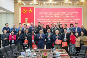 Lãnh đạo, cán bộ Báo Nhân Dân, đại diện Bộ Ngoại giao và Đoàn phóng viên nước ngoài chụp ảnh lưu niệm. (Ảnh: BẢO LONG)