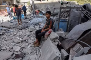 Một cậu bé Palestine ngồi giữa đống đổ nát sau cuộc không kích của Israel nhằm vào khu vực Al-Zawaida, trung tâm Dải Gaza, ngày 25/9/2025. (Ảnh: Tân Hoa xã)