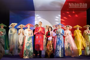 Đại sứ Pháp Olivier Brochet (áo dài đỏ) chúc mừng nhà thiết kế Hàn Phượng (cầm hoa) sau màn trình diễn áo dài.