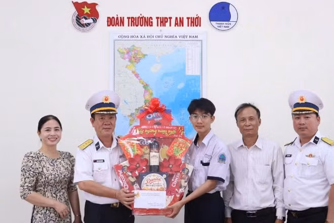 Thượng tá Đoàn Văn Khương, Phó Lữ đoàn trưởng Lữ đoàn 127 trao quà cho con ngư dân. (Ảnh do Vùng 5 Hải quân cung cấp)