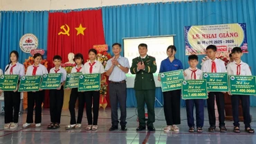 Đại diện lãnh đạo Ban Chỉ huy Bộ đội Biên phòng tỉnh Đắk Lắk và chính quyền địa phương trao quà tặng cho các em học sinh tại xã Ia Rvê.