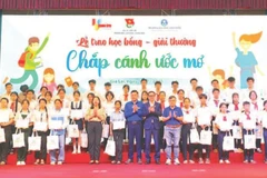 Các em học sinh có hoàn cảnh khó khăn nhận học bổng "Chắp cánh ước mơ" . (Ảnh DŨNG NHÂN)