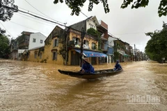 Nước ngập sâu, người dân sử dụng thuyền để di chuyển trong đô thị.