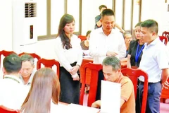 Lãnh đạo xã Phú Xuyên kiểm tra công tác hỗ trợ người dân làm thủ tục cấp giấy chứng nhận quyền sử dụng đất. (Ảnh CÔNG TÂM)