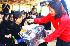 Lãnh đạo Hội Chữ thập đỏ trao quà cho các học sinh trên địa bàn. (Ảnh LƯƠNG THẢO)