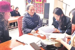 Cán bộ xã Tuyên Sơn, tỉnh Quảng Trị chi trả tiền quà Tết, tặng người dân.