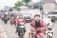 Xe gắn máy lưu thông trên các tuyến quốc lộ cửa ngõ ra vào Thành phố Hồ Chí Minh. (Ảnh THẾ ANH)