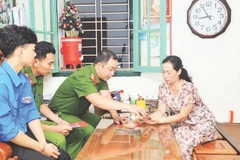 Cán bộ công an và đoàn viên, thanh niên phường Cửa Nam hướng dẫn người dân sử dụng ứng dụng dịch vụ hành chính công. (Ảnh LÊ HẢI)