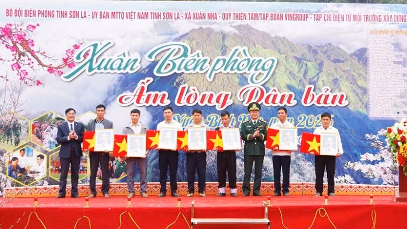 Lãnh đạo Ban Chỉ huy Bộ đội Biên phòng tỉnh Sơn La và lãnh đạo xã Xuân Nha tặng ảnh Bác Hồ, cờ Tổ quốc cho các bản biên giới.