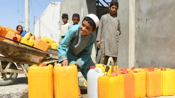 Trẻ em Afghanistan lấy nước sạch từ vòi nước công cộng ở tỉnh Kandahar, Afghanistan, ngày 12/7/2023. (Ảnh: Arghand/Xinhua)