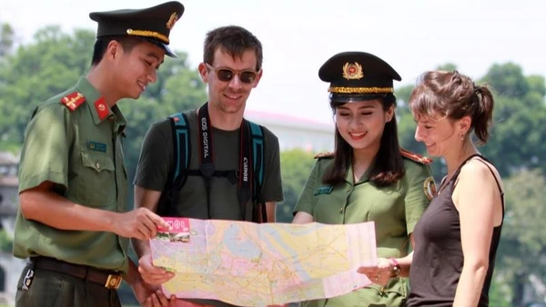 Chiến sĩ Công an thành phố Hà Nội hỗ trợ khách du lịch nước ngoài tham quan Thủ đô. (Ảnh: Lam Thanh)