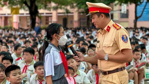 Cán bộ Phòng Cảnh sát giao thông, Thành phố Hồ Chí Minh trao đổi với một học sinh về an toàn giao thông. 