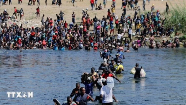 Người di cư vượt sông Rio Bravo từ Mexico để vào Mỹ. (Ảnh: THX/TTXVN)