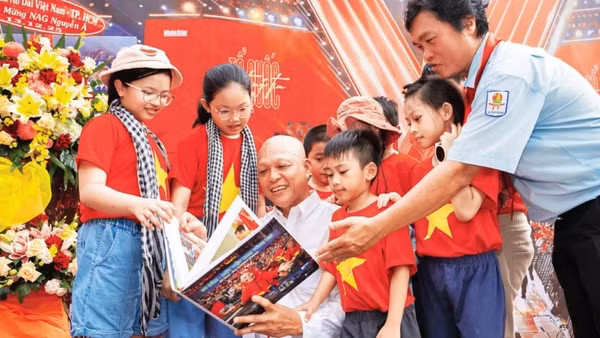 Nghệ sĩ nhiếp ảnh Nguyễn Á (áo trắng) giới thiệu sách ảnh tới công chúng.