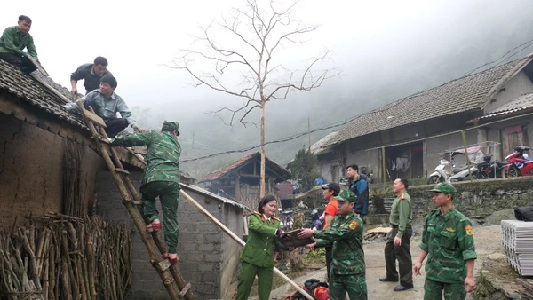 Các lực lượng chức năng hỗ trợ người dân xã biên giới Tùng Vài khắc phục hậu quả thiên tai.