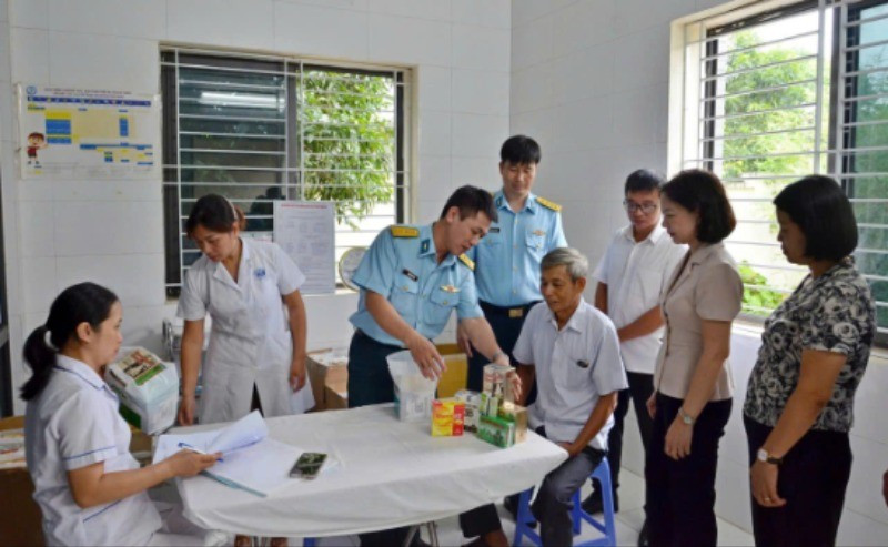 Đại diện lãnh đạo phường Tùng Thiện và Học viện Phòng không-Không quân khám bệnh, cấp thuốc miễn phí cho người có công. 