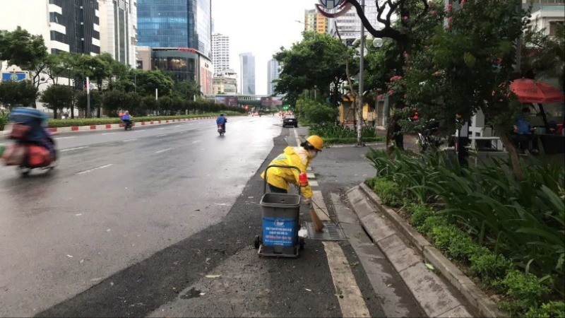 Công nhân Công ty Thoát nước Hà Nội vệ sinh các miệng thu nước trên đường Nguyễn Chí Thanh. (Ảnh: CẢNH HOÀNG)