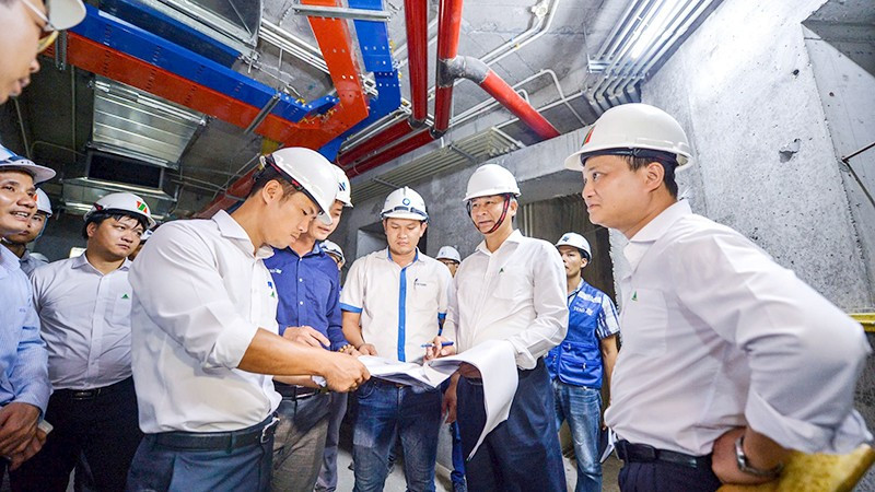 Cán bộ Công ty cổ phần Đầu tư Phát triển Nhà Constrexim kiểm tra tiến độ công trình. Ảnh trong bài | THÀNH ĐẠT