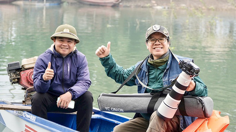 Nhà báo Đỗ Doãn Hoàng (phải) thực hiện phóng sự dài kỳ trên Nhân Dân cuối tuần về tình trạng đánh bắt cá trái phép trên hồ Thác Bà (Lào Cai), tháng 1/2026.