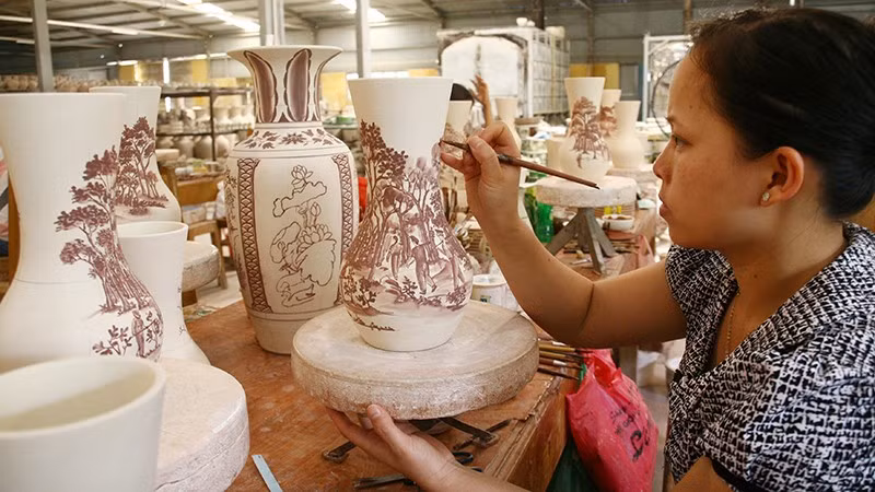 Vẽ trang trí trên sản phẩm tại Công ty cổ phần gốm Chu Đậu (Hải Phòng). Ảnh | KHIẾU MINH