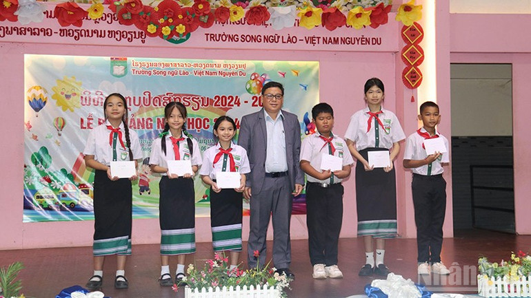 Đại diện Sở Giáo dục và Thể thao thủ đô Vientiane trao phần thưởng tặng các em học sinh Khối Tiểu học có thành tích tốt trong kỳ thi tốt nghiệp. (Ảnh: HẢI TIẾN) ndo_br_2.jpg