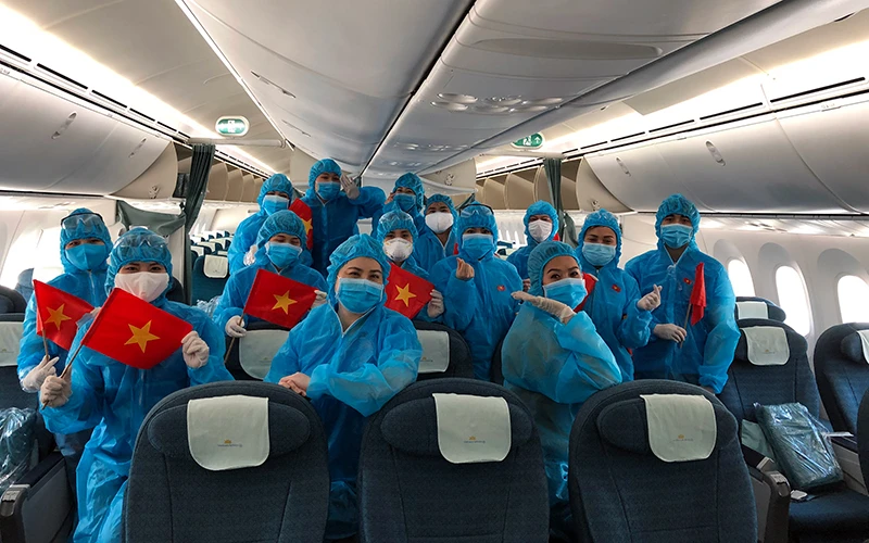 Tổ bay Vietnam Airlines trước khi khởi hành chuyến bay hồi hương cho công dân Anh từ Việt Nam và cho công dân Việt Nam từ Anh về nước. Nguồn: VNA