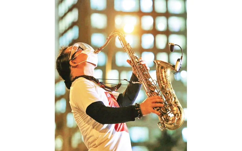 Nghệ sĩ saxophone Trần Mạnh Tuấn biểu diễn tại Bệnh viện dã chiến thu dung số 3 TP Hồ Chí Minh. Ảnh: Quỳnh Hoa 