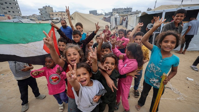 Trẻ em Palestine ăn mừng tại một trại dành cho người di tản ở Nuseirat, miền trung Dải Gaza. Ảnh | Eyad Baba/AF/Getty Images tre-em-palestine-an-mung-tai-mot-trai-danh-cho-nguoi-di-tan-o-nuseirat-mien-trung-dai-gaza-anh-eyad-baba-af-getty-images.jpg