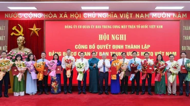 Các đồng chí Đỗ Văn Chiến, Hà Thị Nga (thứ tám và chín từ phải sang) trao Quyết định, tặng hoa chúc mừng người đứng đầu các tổ chức đảng ở các đơn vị trực thuộc Cơ quan Ủy ban Trung ương Mặt trận Tổ quốc Việt Nam.
