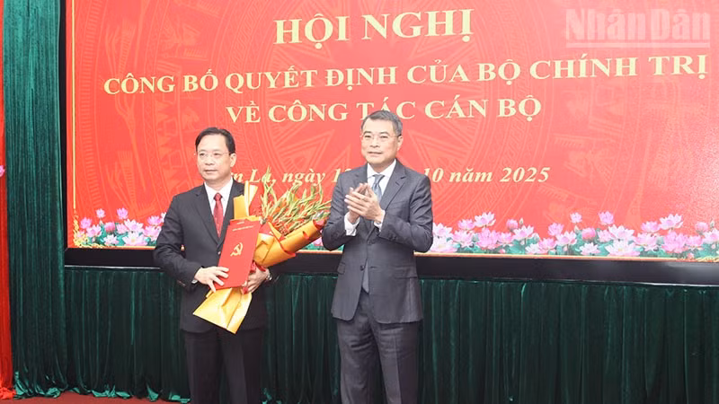 Đồng chí Lê Minh Hưng, Ủy viên Bộ Chính trị, Bí thư Trung ương Đảng, Trưởng ban Tổ chức Trung ương trao quyết định của Bộ Chính trị và tặng hoa chúc mừng đồng chí Hoàng Văn Nghiệm.