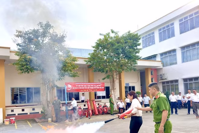 Công an phường Long Trường hướng dẫn người dân sử dụng bình chữa cháy khi có hỏa hoạn.