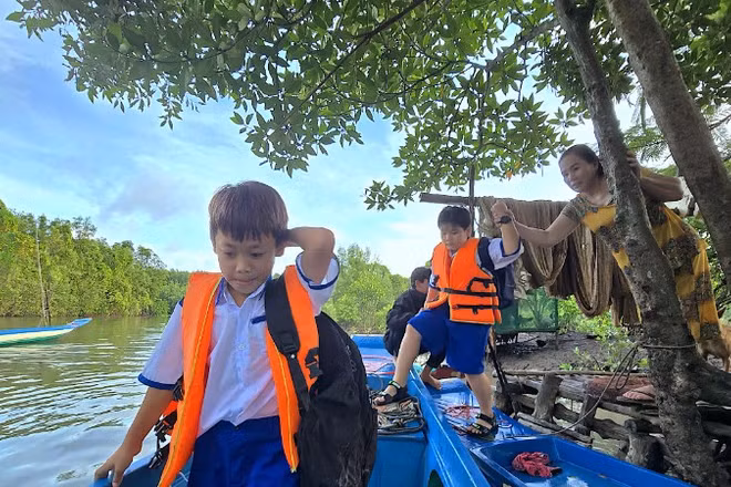 Con em miệt rừng xã Đất Mũi, tỉnh Cà Mau phải dậy từ sớm để kịp giờ đến trường trên những chiếc đò đưa rước học sinh. 