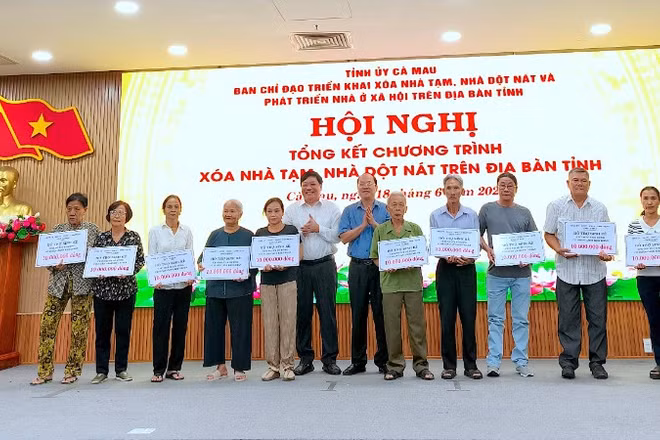 Bí thư Tỉnh ủy Cà Mau Nguyễn Hồ Hải (đứng giữa, áo sơ mi xanh) trao hỗ trợ sinh kế cho người dân tại hội nghị tổng kết chương trình xóa nhà tạm, nhà dột nát.