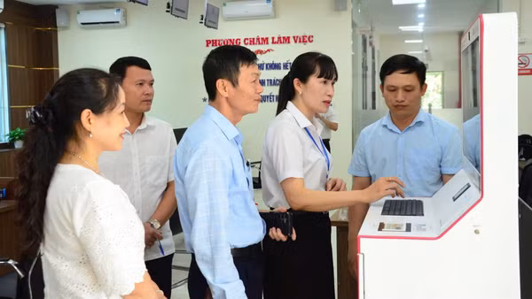Cán bộ Trung tâm Phục vụ hành chính công phường Hàm Rồng, tỉnh Thanh Hóa hỗ trợ, hướng dẫn sử dụng kiosk thông minh trong triển khai thủ tục hành chính công. (Ảnh: MINH CHÍNH)