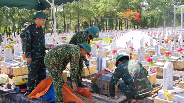 Thành viên Đội 584 (Bộ Chỉ huy quân sự tỉnh Quảng Trị) lấy mẫu để giám định ADN ở phần mộ liệt sĩ chưa xác định được thông tin. (Ảnh HIẾU MINH)