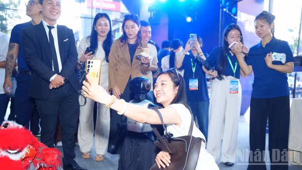 Các đại biểu chụp hình cùng robot tại sự kiện. (Ảnh: CTV)