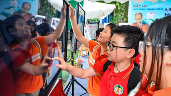 Các em học sinh hào hứng tiếp cận nội dung báo chí đa nền tảng của Báo Nhân Dân. (Ảnh minh họa: KIM ẢNH)