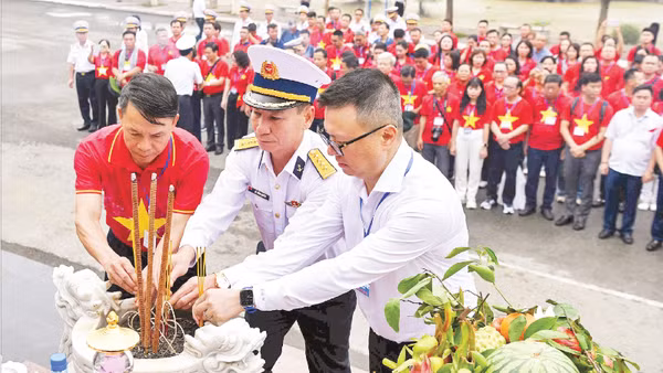 Đồng chí Lê Quốc Minh, Tổng Biên tập Báo Nhân Dân và lãnh đạo Đoàn công tác số 25 cùng đội ngũ những người làm báo dâng hương tại Tượng đài tưởng niệm các chiến sĩ Đoàn tàu không số anh hùng. (Ảnh: ĐỨC NGHĨA)