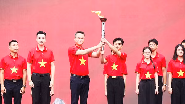Chủ tịch T.Ư Hội LHTN Việt Nam Nguyễn Kim Quy trao ngọn đuốc "Tôi yêu Tổ quốc tôi" cho đại diện thanh niên cả nước. Ảnh: TUẤN MINH